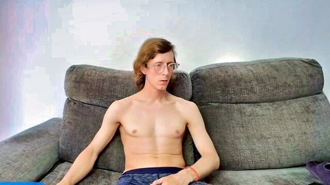 Young shirtless guy with glasses exposing erect penis, smoking solo
