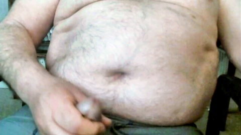 Hairy chubby mature man stroking erect cock in gay handjob scene