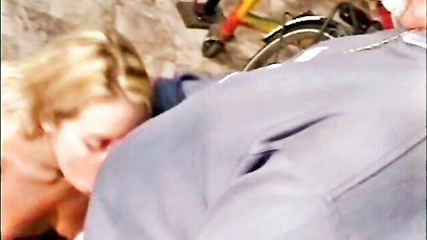 Blonde teen outdoors giving blowjob to older man with exposed breasts