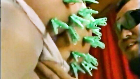Japanese woman with green clothespins on nipples in intimate BDSM play