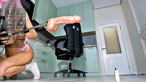 Skinny Asian webcam slut spreads legs holding massive pink dildo at her shaved pussy in kitchen
