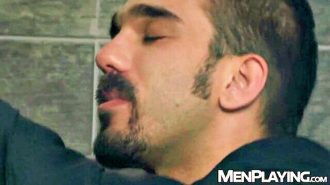 Close-up of handsome bearded brunette hunk eyes closed moaning in gay sex ecstasy