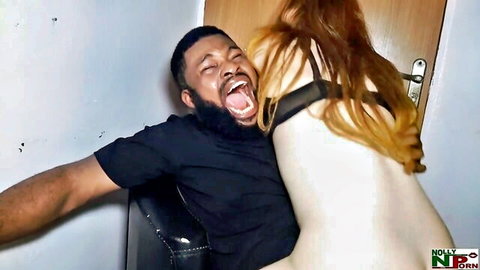 Bearded black man roughly bites and grips nude redhead's pale ass and sideboob on leather chair