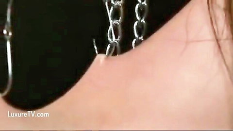 Japanese woman in BDSM collar with dangling chains, sadomasochism piercing theme