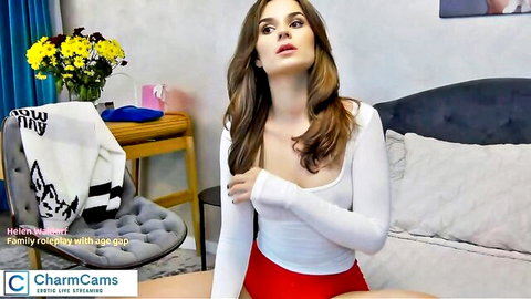 Brunette woman in white top and red shorts on webcam chat