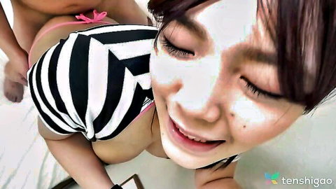 Manami Takashima smiling playfully with big tits in striped bikini
