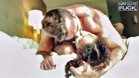 Muscular white stud passionately kissing nude curvy ebony babe on bed during hot sex