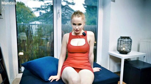 Blonde Mandala in revealing red cutout dress, seductive sitting pose