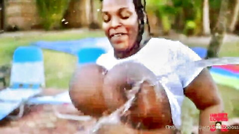 Curvy ebony woman in wet white t-shirt revealing huge breasts outdoors