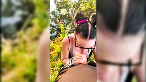 POV of glasses girl with pink buns kneeling in forest sucking cock outdoors