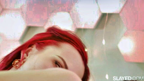 Seductive redhead with intense gaze and fiery hair in steamy pink lights