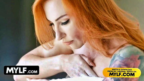 Redhead MILF with massive tits in seductive pose, tattoos visible