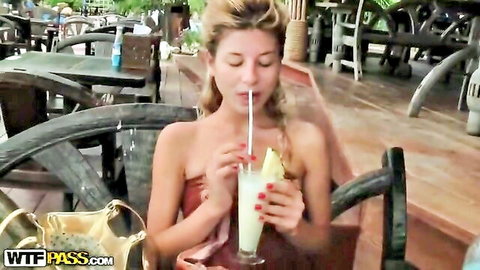 Sexy blonde in red strapless dress sips pineapple cocktail on Thai vacation
