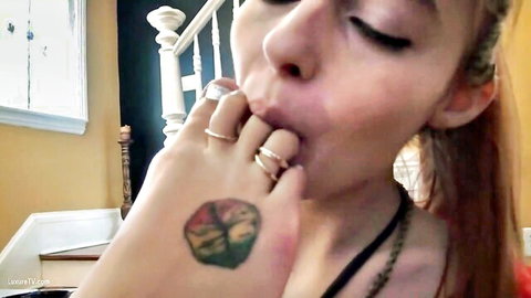 Redhead mistress's big tattooed feet with toe rings, slave sucking toes in femdom fetish
