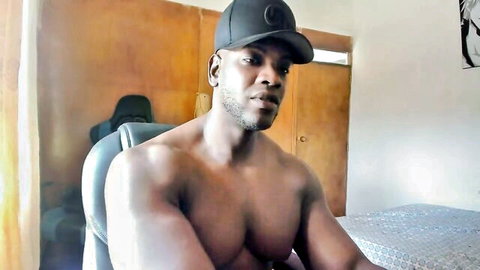 Huge naked black muscle hunk posing shirtless in chair