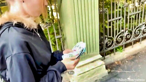 Yuiwoo in fur-trimmed hoodie holding phone outdoors, teasing smile