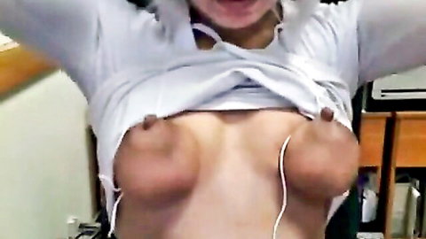 Asian woman exposes large breasts through torn white shirt in tit torture scene