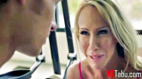 Blonde MILF smiling seductively at young guy in close-up taboo car flirt