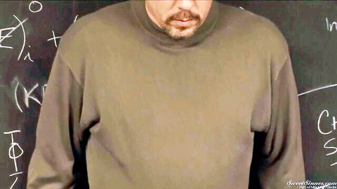 Bearded teacher in turtleneck sweater stands at chalkboard in college classroom taboo scene