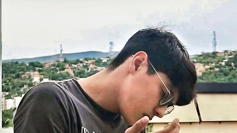 Young Asian man in glasses on balcony, teasing seduction after selling motorcycle