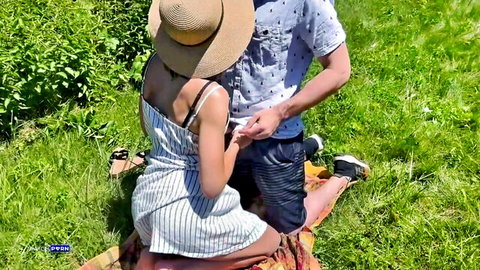 Curvy brunette in straw hat sundress kneels on picnic blanket as man grabs her big ass outdoors