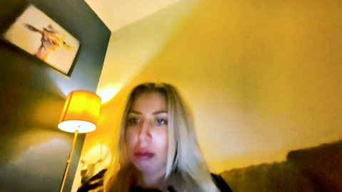 Size10doubleg blonde camgirl with intense gaze in warm lighting