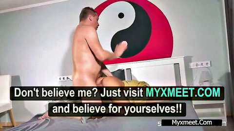 Naked muscular man fucking woman doggy style on bed with yin yang wall behind