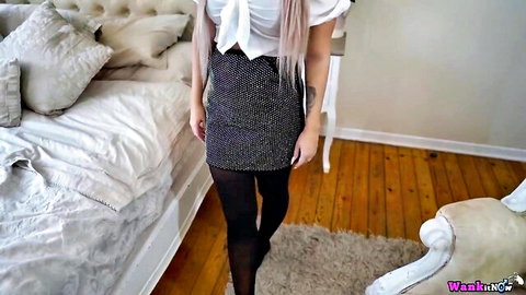 Pink-haired babe in sparkly mini skirt and black stockings poses seductively in bedroom