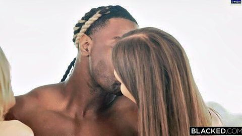 Muscular black bull with dreads passionately kissing long-haired white babe as blonde watches in threesome