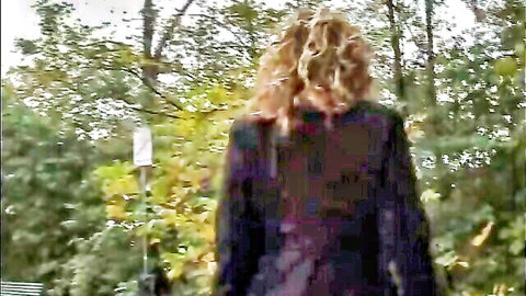 Veronica Belli in seductive outdoor pose, curly blonde hair, autumn woods tease