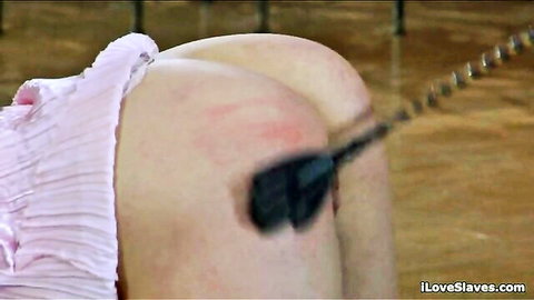 Petite slave bent over for spanking punishment in pink ruffled lingerie
