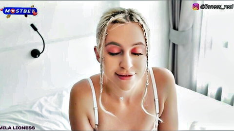 Blonde stepmom in white lingerie smiling seductively on bed, caught masturbating