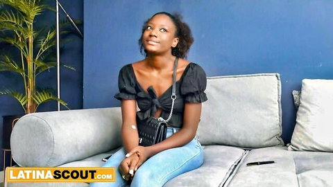 Cute black Latin teen babe smiling in off-shoulder top and jeans, casting tease