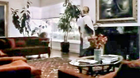 Blonde woman in white top carrying red flowers in elegant room setup