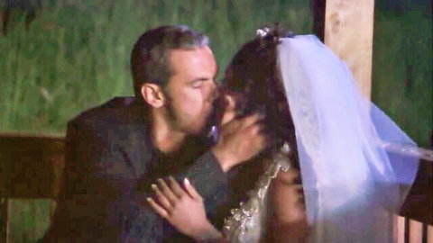 Monica Mayhem in wedding veil passionately kissing suited groom