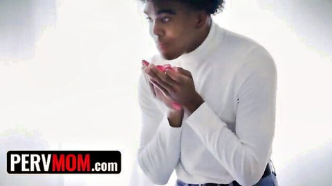Excited young black stud in white turtleneck holds pink sex toy near open mouth teasing blowjob