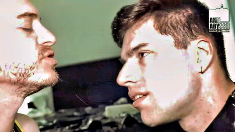 Two young gay men with short hair staring intensely nose-to-nose in intimate closeup