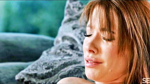 Sensual close-up of brunette woman with bangs, eyes closed in ecstasy, soft lips parted