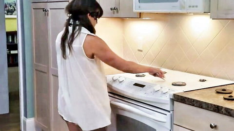 Brunette MILF in short white dress teases ass cooking at kitchen stove