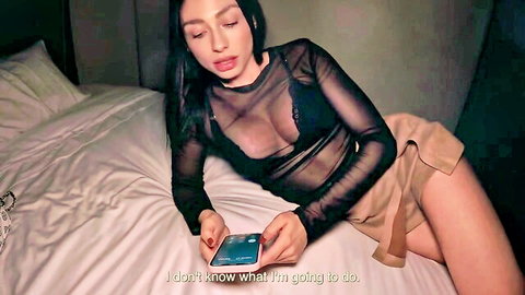 Miss Ary Colombian model in sheer black lingerie and skirt on bed, holding phone confused