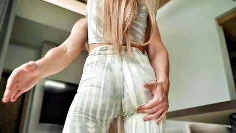 Blonde Asian babe with pants down, grabbing her round ass from behind