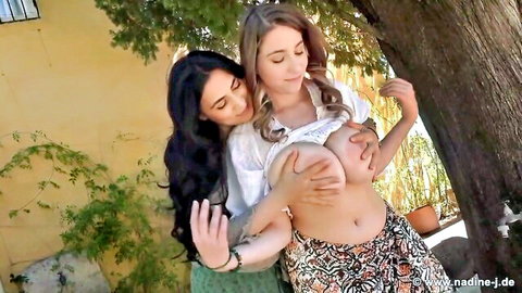 Luna Amor and Yonia busty lesbians embracing, big tits groped outdoors