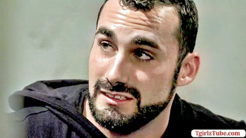 Handsome bearded brunette man in black hoodie closeup portrait looking intense