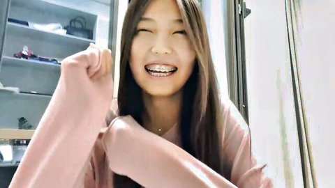 Shy young Asian camgirl michalkandoll smiling with braces in pink top