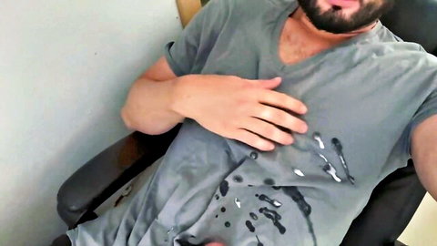 Bearded man in gray t-shirt masturbating solo with cum stains on shirt
