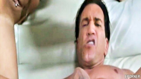 Brunette giving intense blowjob to muscular man moaning in ecstasy on white bed