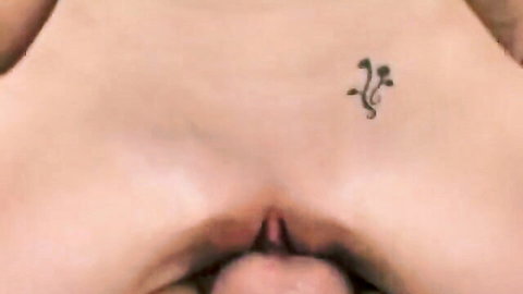 Closeup of shaved bald pussy with pink labia and mushroom tattoo above