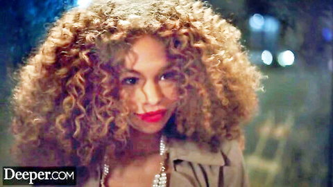Seductive curly-haired ebony beauty with red lips smirking in open trench coat
