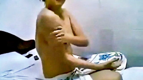 Shirtless Indonesian amateur teen sitting on bed with arms crossed over bare chest