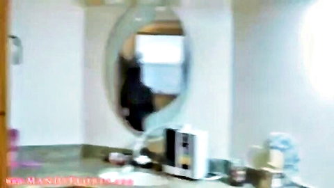 Mandy Flores reflecting in home bathroom mirror, casual pose
